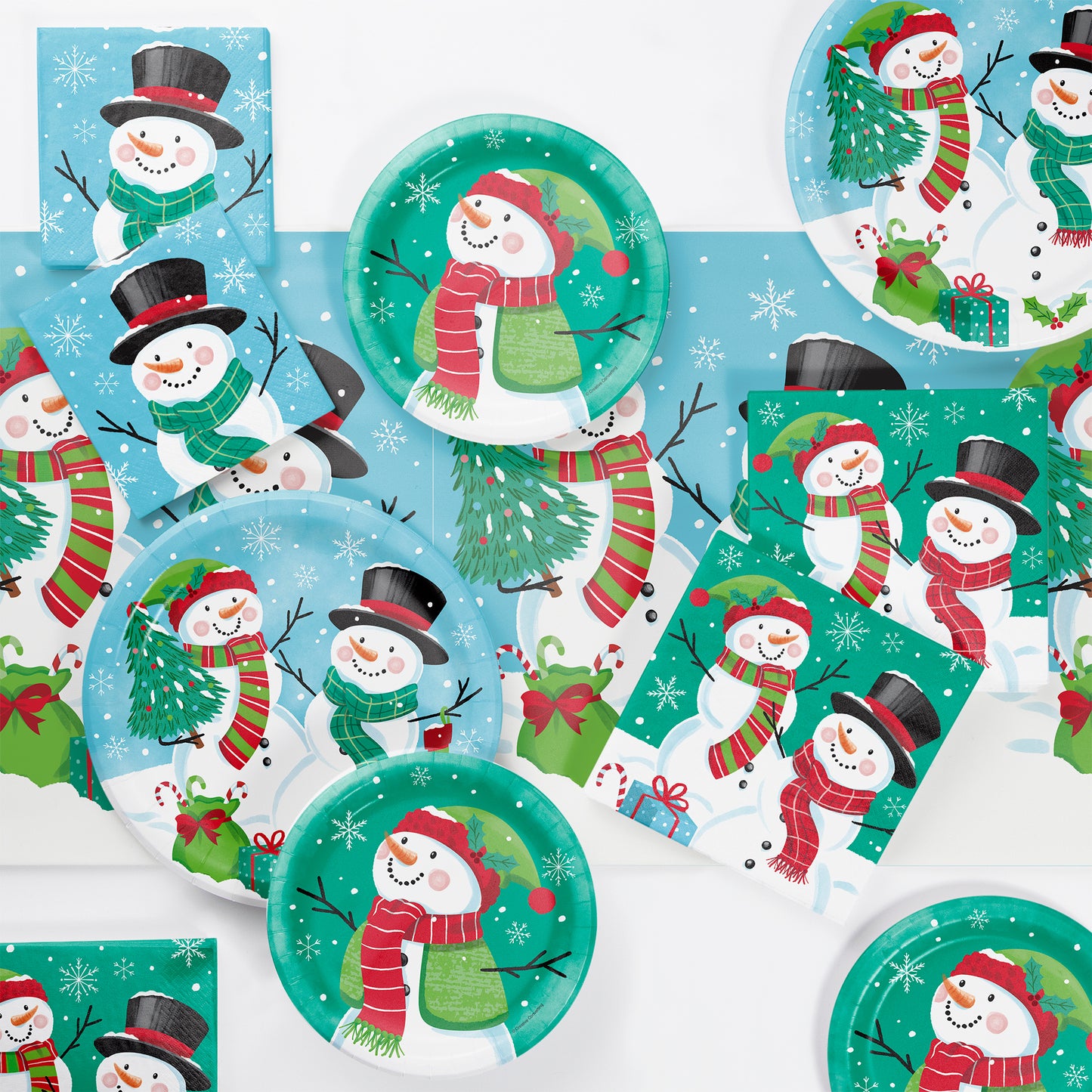 Set of Christmas-themed paper plates and napkins with snowmen and winter scenes.