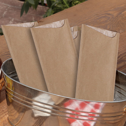 Brown paper cutlery pouches in a metal bucket on a wooden surface
