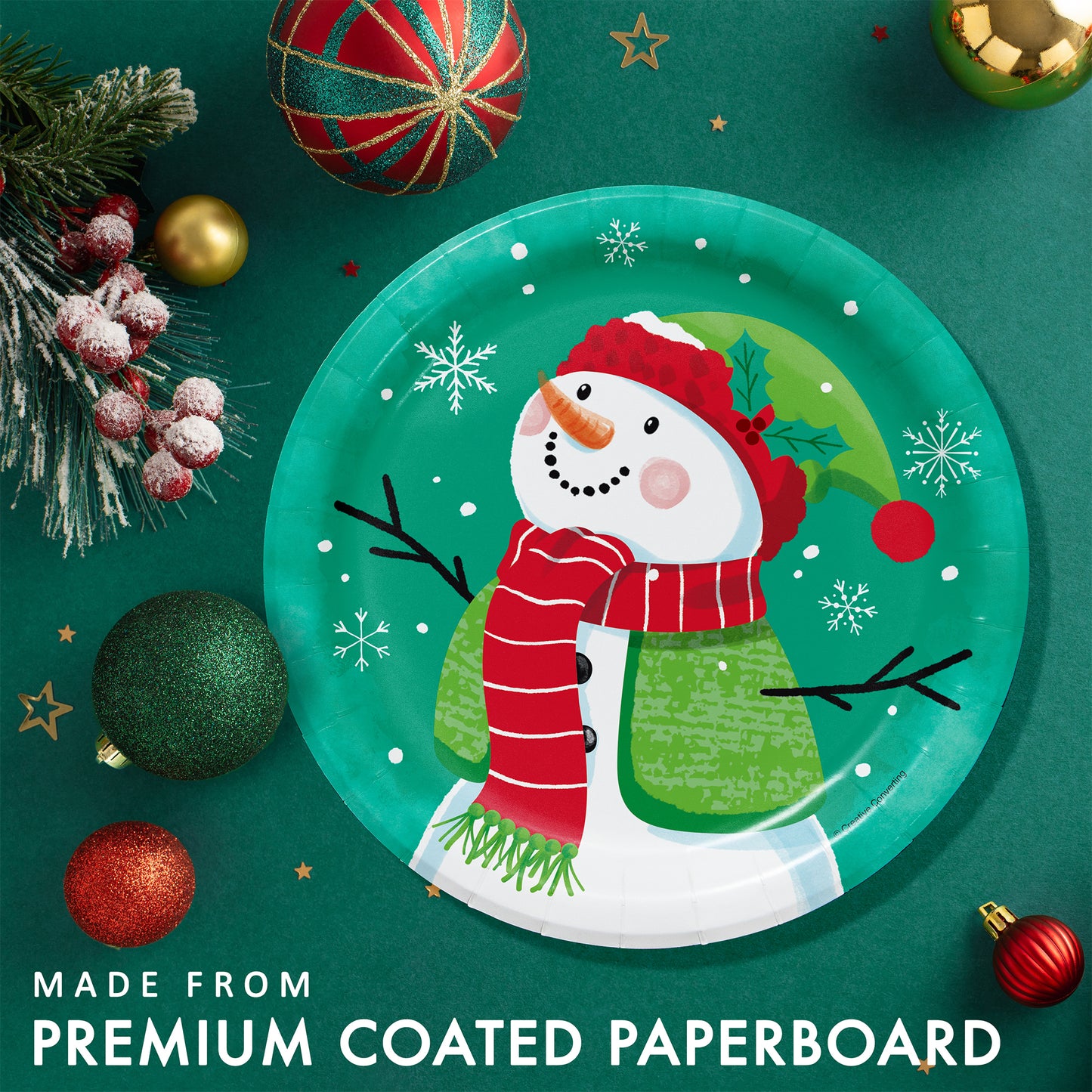 Frosty Friends Dessert Paper Plates 96 ct. Christmas-themed paper plate with a snowman design on a green background placed on a green table with festive decorations.