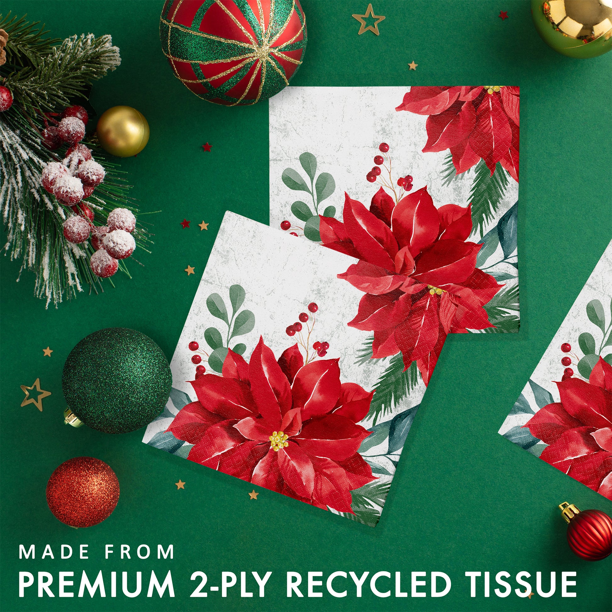 Red poinsettia floral design paper napkin with Christmas decorations on a green background.