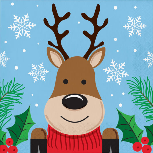 Christmas Cheer Luncheon Napkins 192 ct. Paper napkin featuring a cartoon reindeer with a red sweater on a blue background with snowflakes and greenery