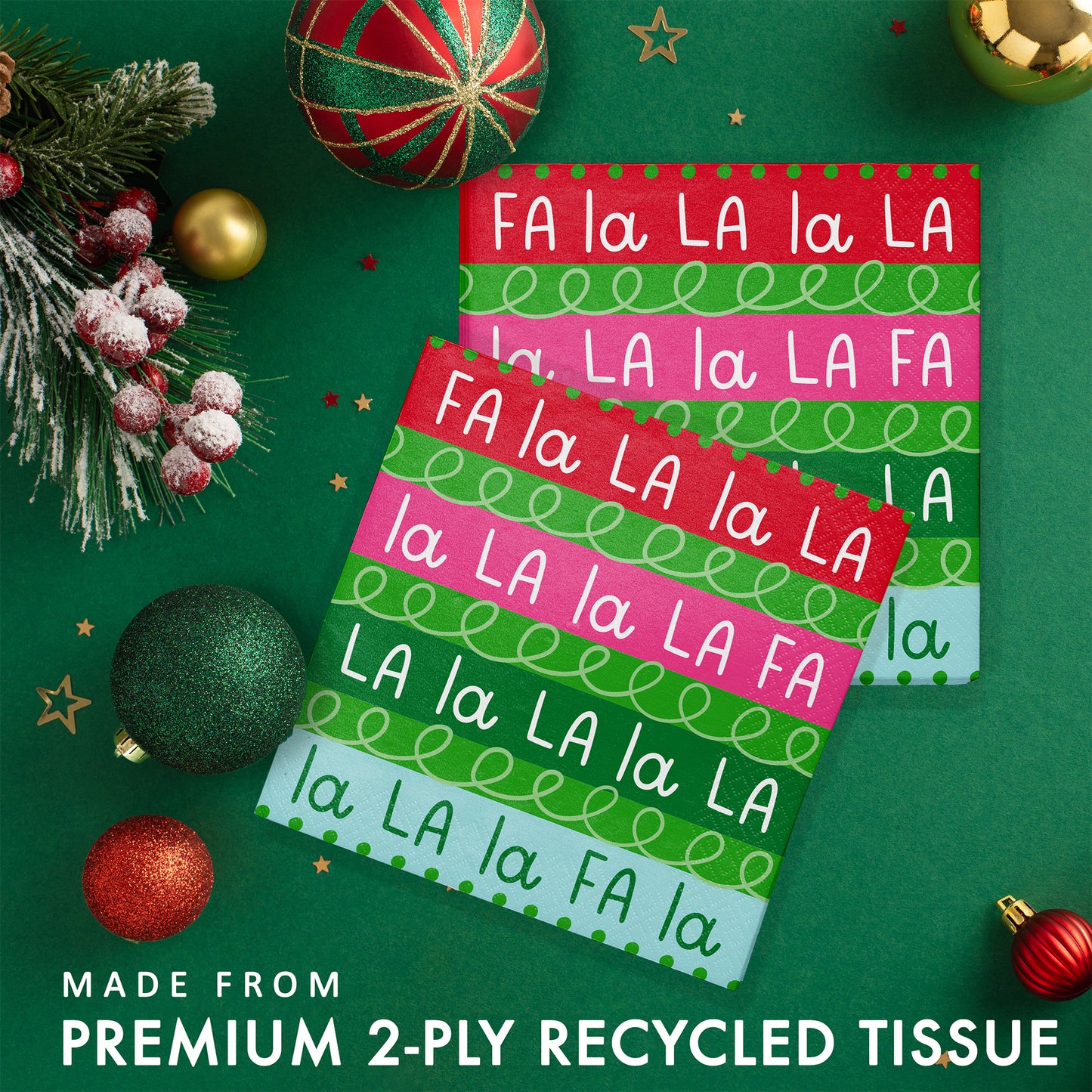 Holiday Frills Luncheon Napkins 192 ct. Stack of colorful paper napkins with Christmas-themed 'FA LA LA' text on a green background with festive decorations.