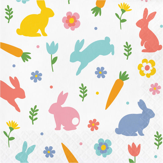 Paper napkin with colorful pattern of bunnies, carrots, and flowers on a white background