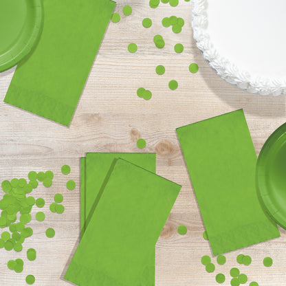 Green paper plates and napkins with green confetti on a wooden surface