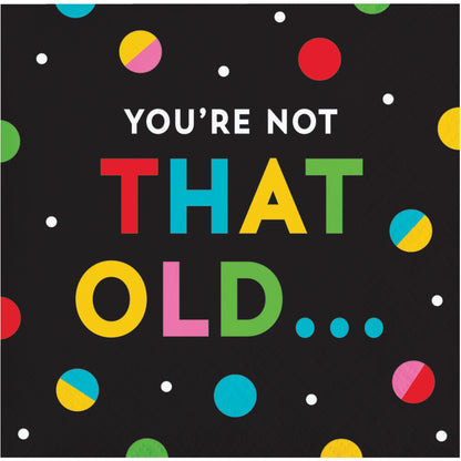 Napkin with colorful text 'YOU'RE NOT THAT OLD...' on a black background with polka dots.