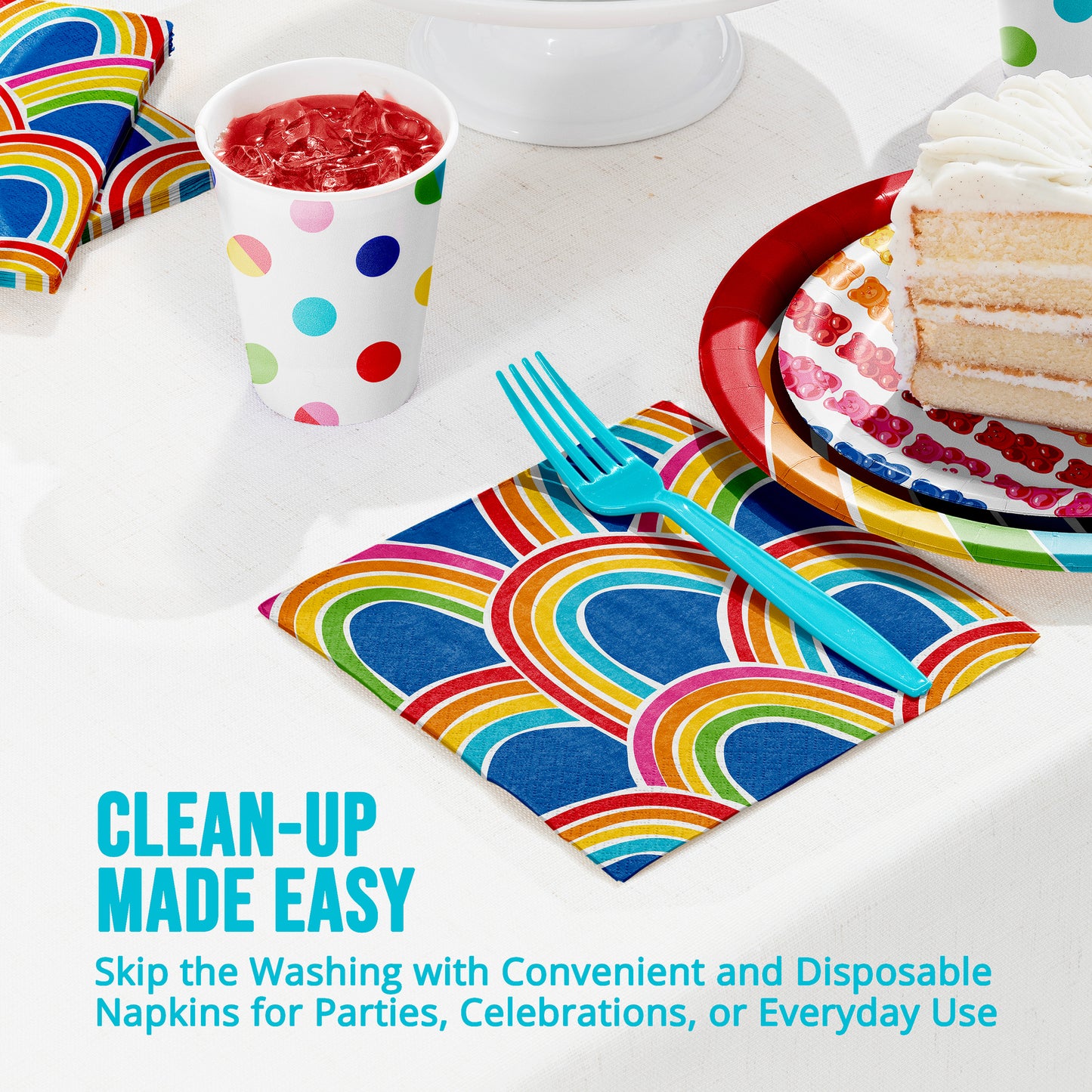 Colorful napkins with rainbow patterns on a table setting with cake, cup, and fork.