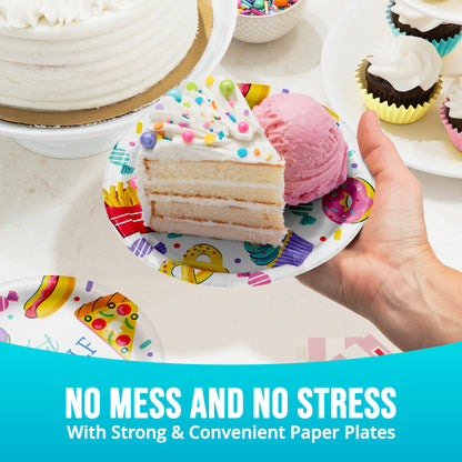 Hand holding a slice of cake on a colorful paper plate with ice cream, surrounded by more cakes and plates.