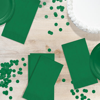 Emerald green pin embossed guest napkins on a wood table with circle confetti