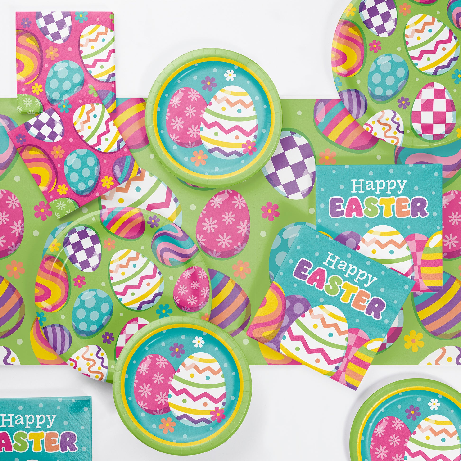 Easter-themed party supplies including plates and napkins displayed on a tablecloth with colorful egg designs on a green background.