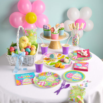 Easter-themed table setting with colorful plates, cups, and decorations.