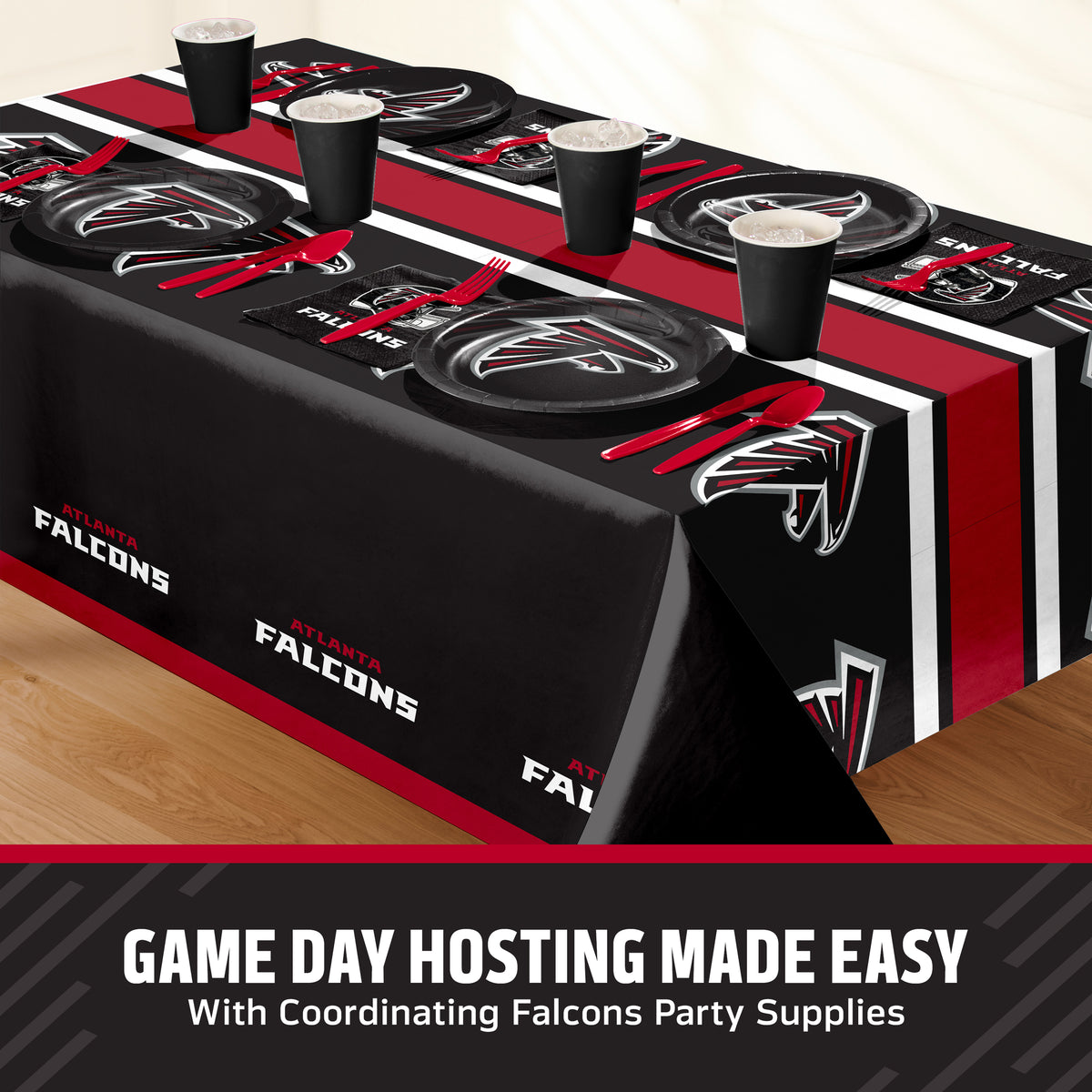 Atlanta Falcons themed party tablecloth and matching tableware set, including black plates, cups, napkins, and placemats with red and white branding, displayed on a table with a promotional banner at the bottom.