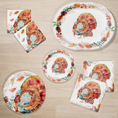 Tasteful Turkey Paper Tablecloths 12 ct. Set of Thanksgiving-themed plates and napkins with turkey and leaf designs on a wooden surface.